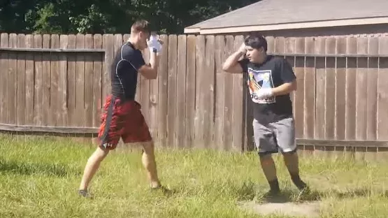 Ein junger Ringer misst sich im Hintergarten gegen einen Muay-Thai-Kämpfer