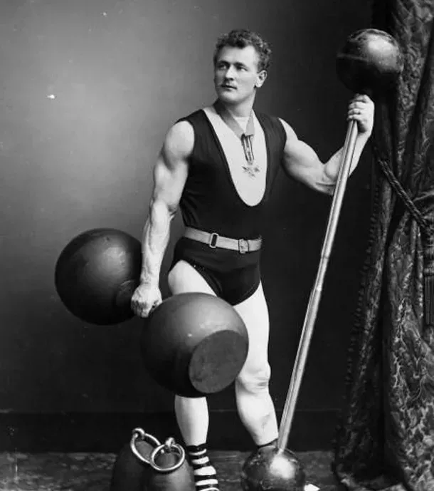 Eugen Sandow (1900): Er posiert stolz mit den Hanteln seiner Zeit. Wie kann man da mit den heutigen Trainingsausrüstungen noch Ausreden finden?