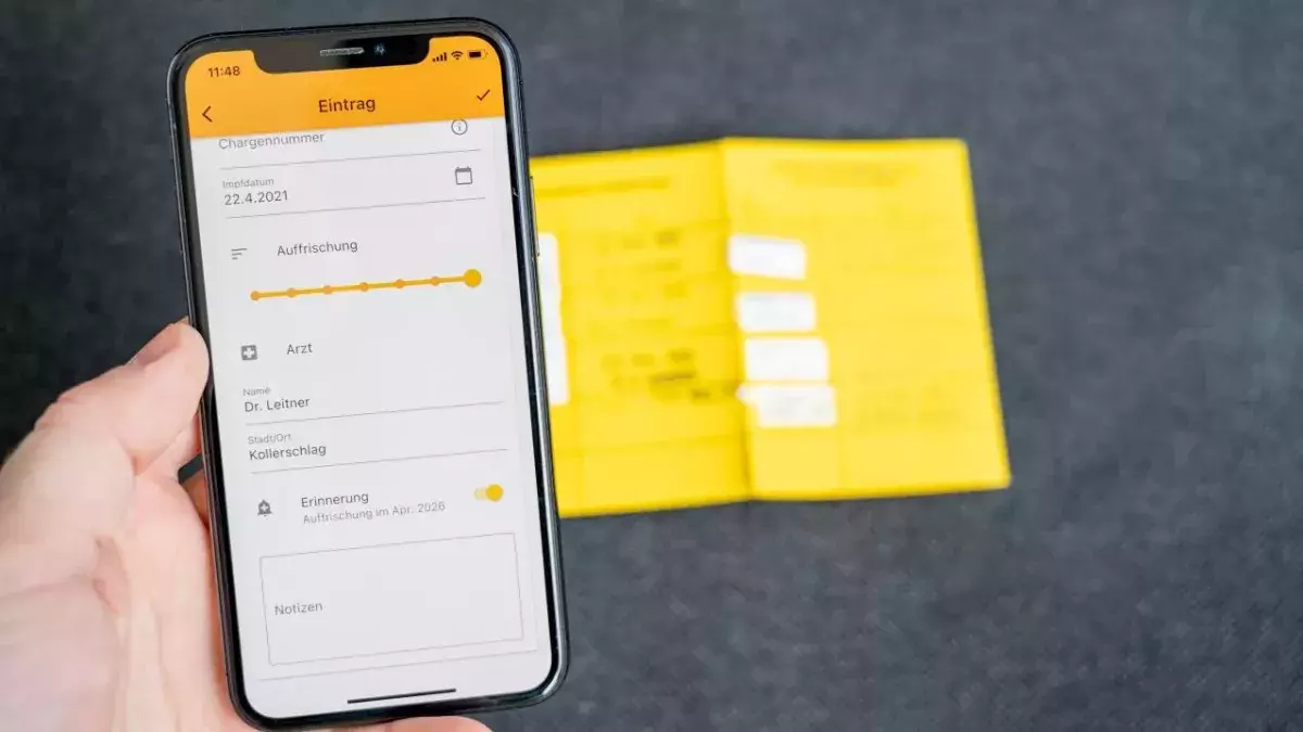 Ein digitaler Impfpass sowie ein gelbes Impfheft