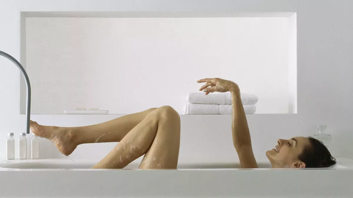 Frau entspannt in der Badewanne, doch dann bleibt sie stecken