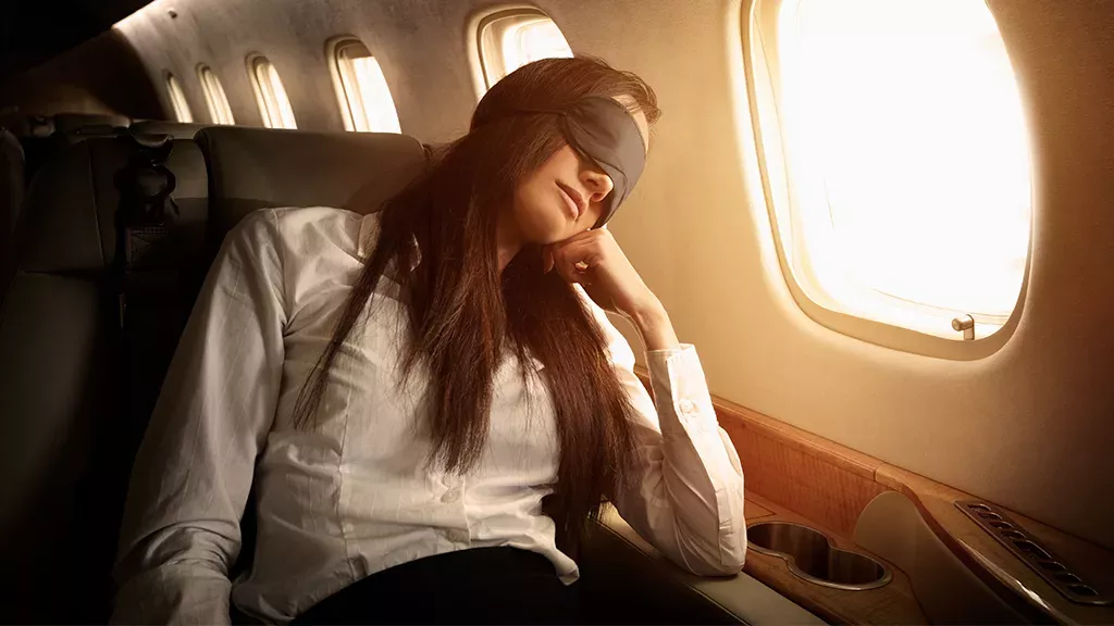 Frau lehnt im Flugzeug den Sitz nach hinten, doch sie bereut es sofort