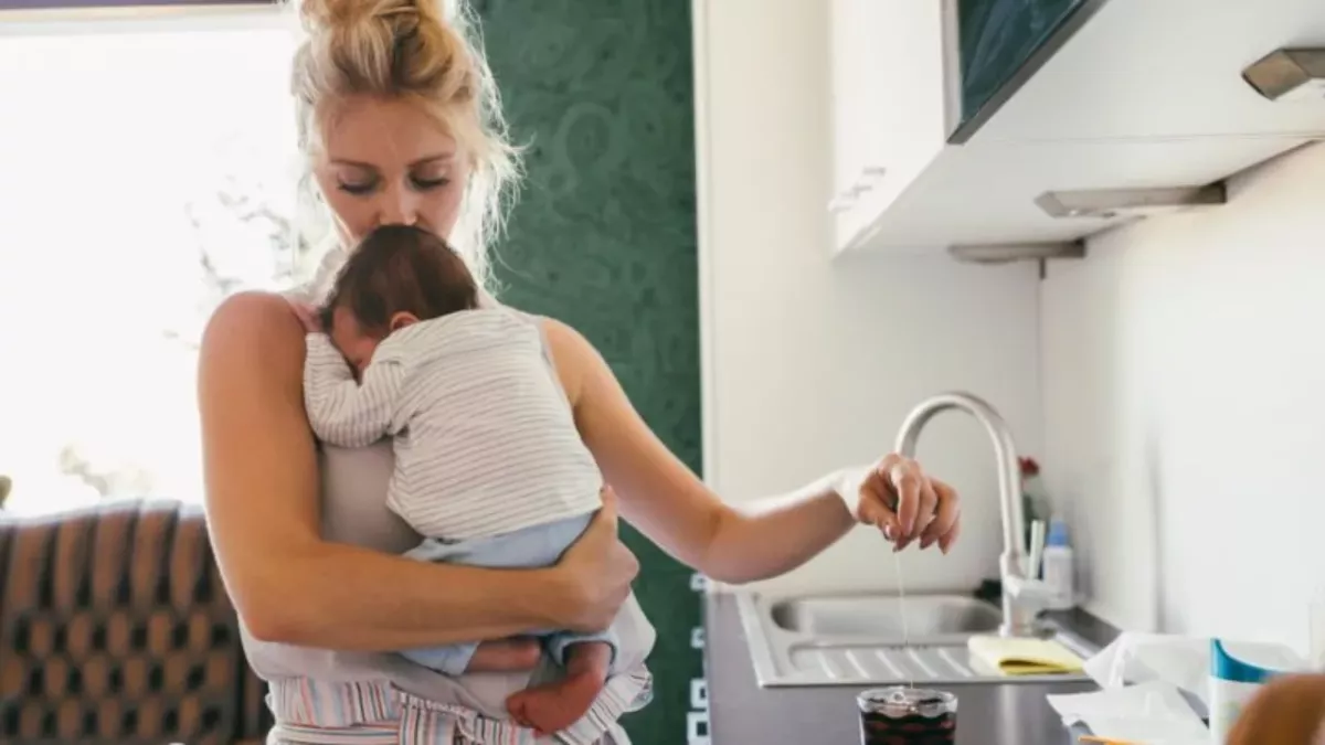 Mutter küsst Kind auf Stirn