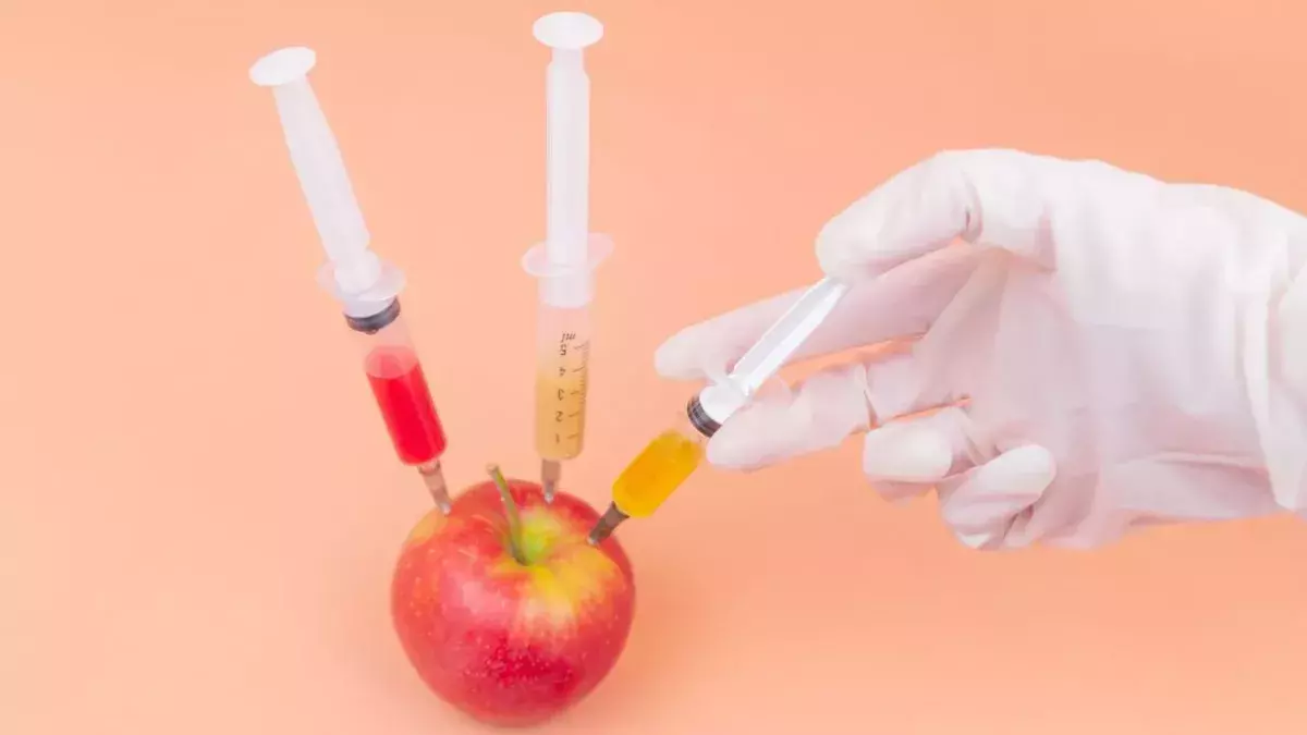 Drei Spritzen werden in einen Apfel injiziert