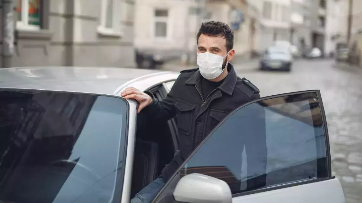 Ein Mann steigt in ein silbernes Auto
