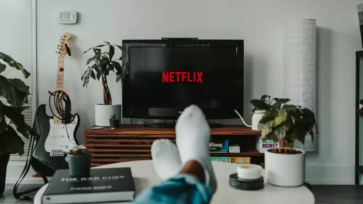 Ein Paar Beine mit Socken vor einem TV mit Netflix-Logo