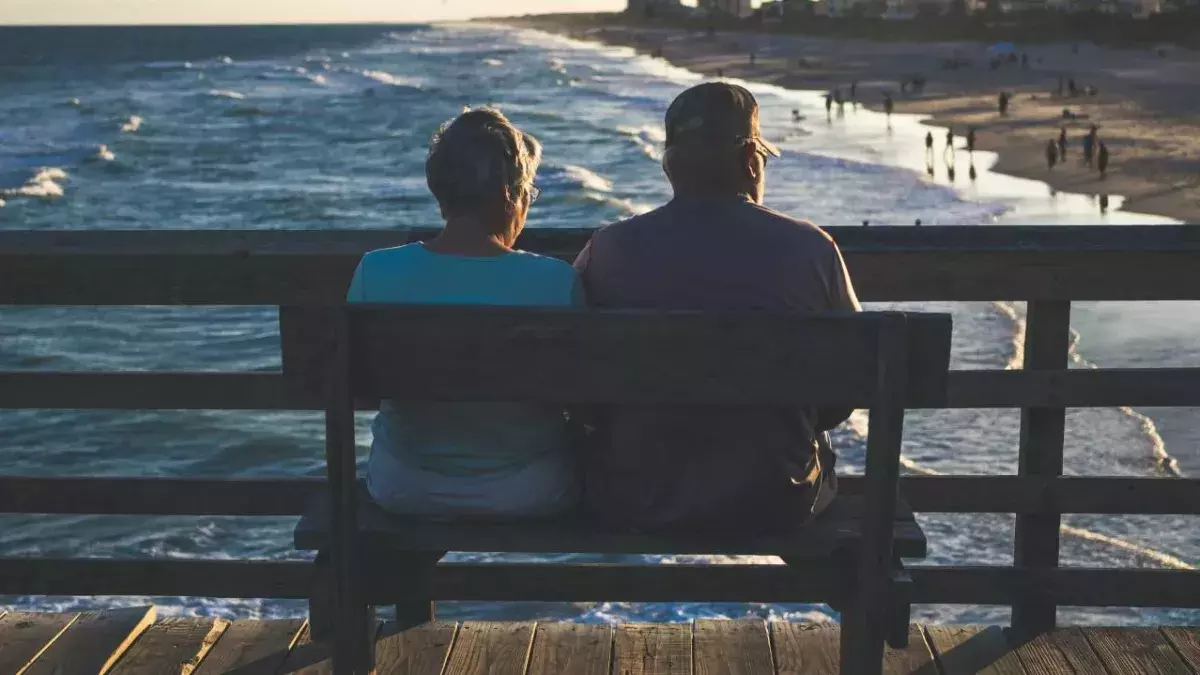 Ein Paar sitzt auf einer Bank am Meer