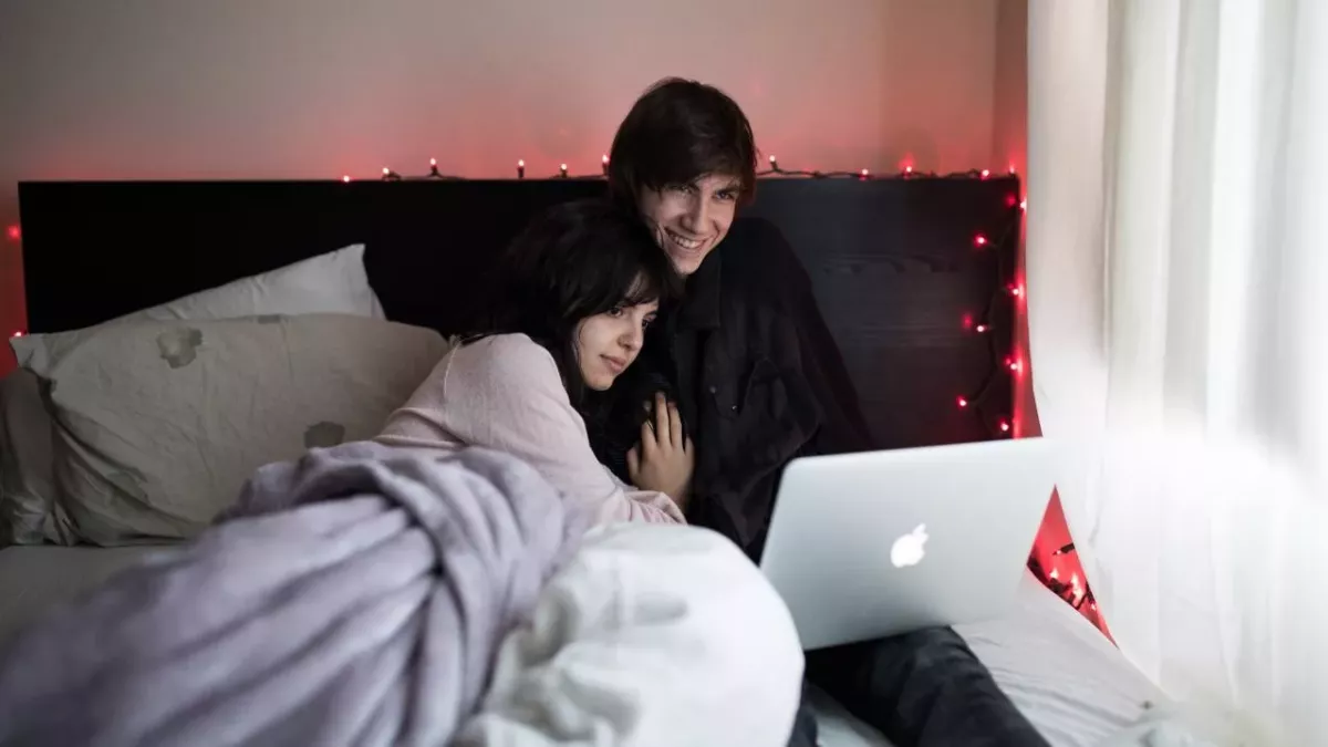 Ein Paar streamt auf einem Laptop im Bett