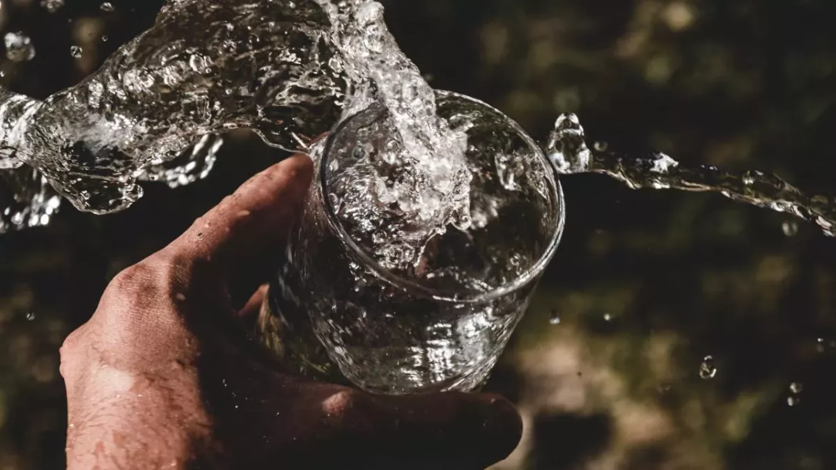 Hand mit einem Glas Wasser