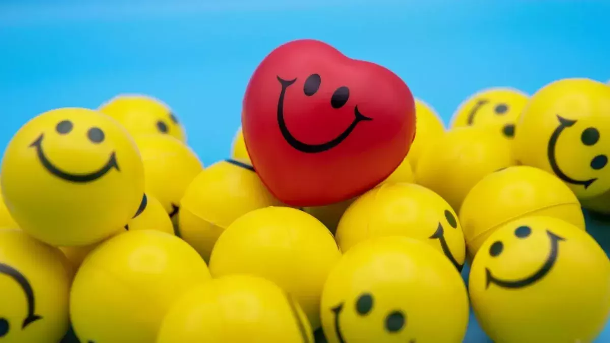 Rotes herzförmiges Smiley inmitten gelber runder Smileys