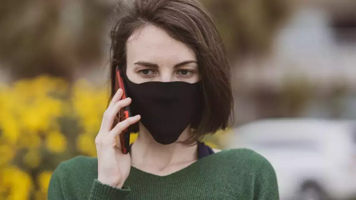 A woman talking on the phone with coronavirus mask