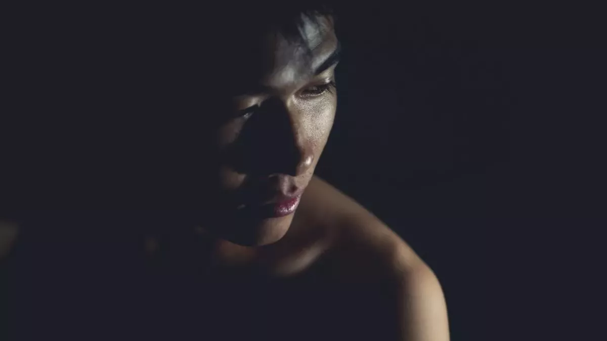 Ein asiatischer Mann posiert im Dunkeln