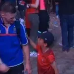 Ein kleiner Junge und Anhänger Portugals tröstet einen französischen Fan