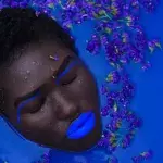 Eine Frau mit blau geschminkten Lippen nimmt ein Bad