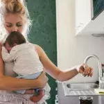 Mutter küsst Kind auf Stirn