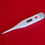 Ein Fieberthermometer auf rotem Hintergrund