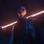 Ein Mann posiert in Blacksuit mit Sonnenbrille