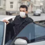 Ein Mann steigt in ein silbernes Auto