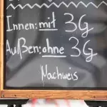 Eine Tafel mit den 3G-Regeln steht vor einem Stuttgarter Restaurant