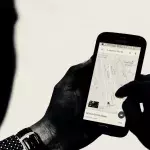 Mann hält Mobiltelefon in den Händen