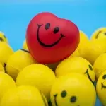 Rotes herzförmiges Smiley inmitten gelber runder Smileys