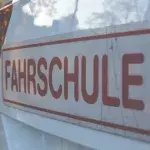 Ein Schild einer Fahrschule ist auf einem KFZ befestigt