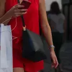 Frau mit H&M-Tüte am Handy
