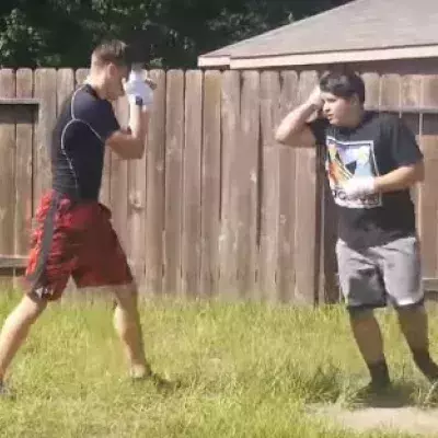 Ein junger Ringer misst sich im Hintergarten gegen einen Muay-Thai-Kämpfer