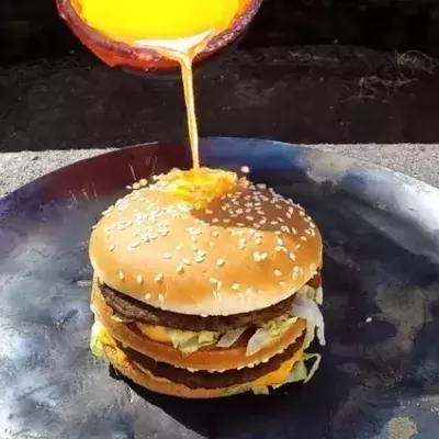 Ein Mann gießt geschmolzenes Kupfer auf einen Big Mac, das Ergebnis ist verblüffend