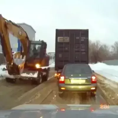 Baggerfahrer hilft einem LKW aus dem Schnee