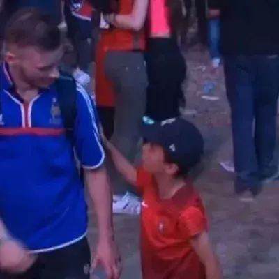 Ein kleiner Junge und Anhänger Portugals tröstet einen französischen Fan