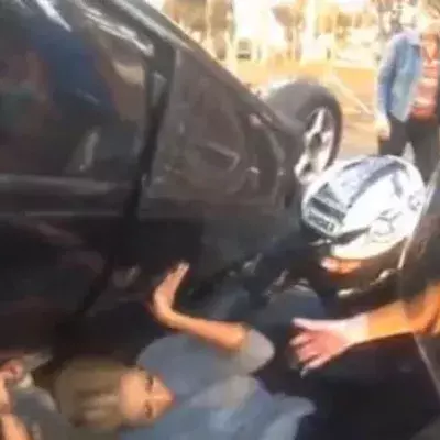 Diese Frau hatte das Glück, dass dieser Motorradfahrer vorbeikam, als sie unter ihrem Auto eingeklemmt war