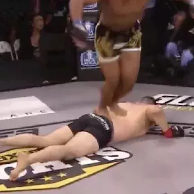 MMA-Kämpfer feiert seinen Sieg mit einem Salto über seinen am Boden liegenden Gegner