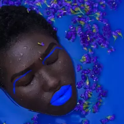 Eine Frau mit blau geschminkten Lippen nimmt ein Bad