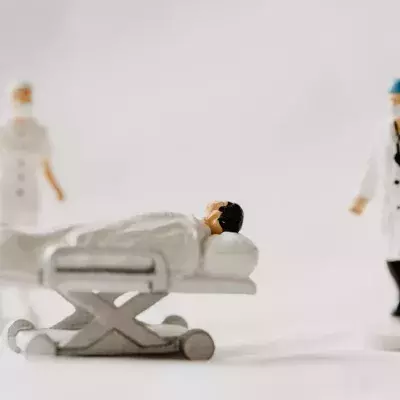 Figuren eines Intensivpatienten und zweier Mediziner