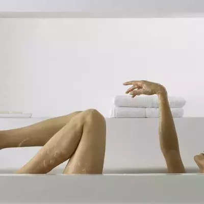 Frau entspannt in der Badewanne, doch dann bleibt sie stecken