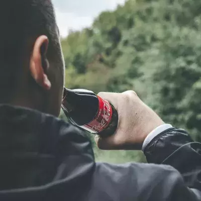 Mann trinkt zu viel Cola