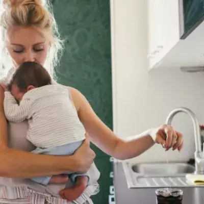 Mutter küsst Kind auf Stirn