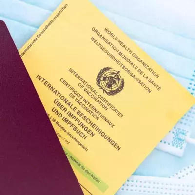 Ein deutscher Reisepass und eine  deutsche Impfbescheinigung liegen auf einem Mund-Nasen-Schutz