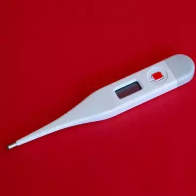 Ein Fieberthermometer auf rotem Hintergrund