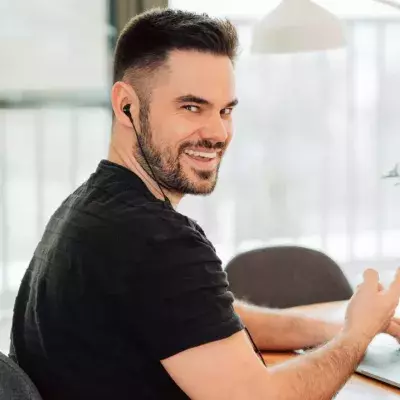 Ein Mann sitzt an einem Apple MacBook Pro am Schreibtisch