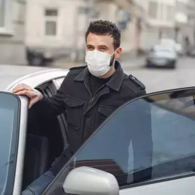 Ein Mann steigt in ein silbernes Auto