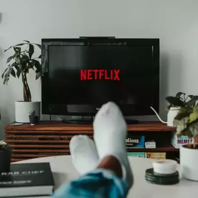 Ein Paar Beine mit Socken vor einem TV mit Netflix-Logo