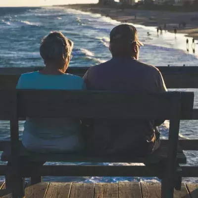 Ein Paar sitzt auf einer Bank am Meer