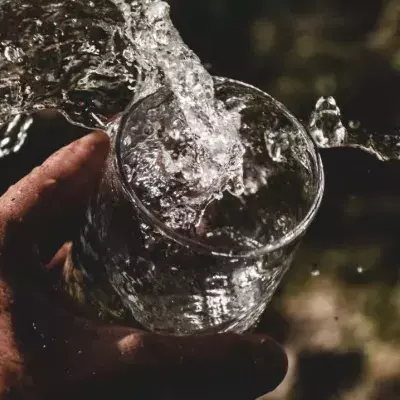 Hand mit einem Glas Wasser