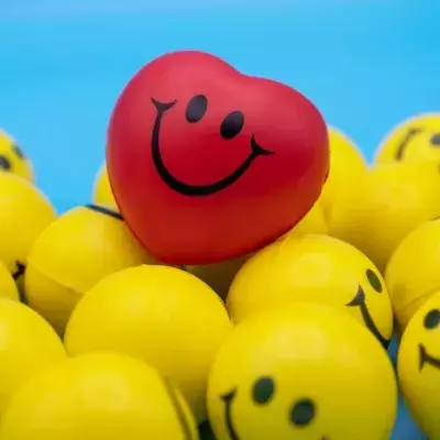 Rotes herzförmiges Smiley inmitten gelber runder Smileys