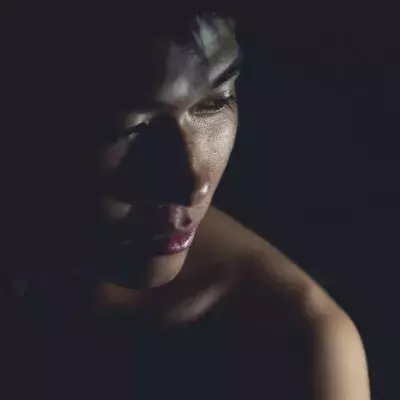 Ein asiatischer Mann posiert im Dunkeln