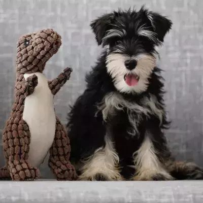Ein Plüsch-Dino sitzt mit einem Hundewelpen auf einer Couch