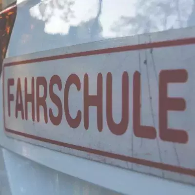 Ein Schild einer Fahrschule ist auf einem KFZ befestigt