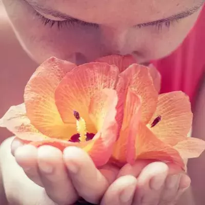Eine Makro-Aufnahme einer Frau, die an gelben Blüten riecht