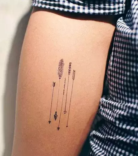 5 winzige Pfeile als graphisches Tattoo auf dem Arm